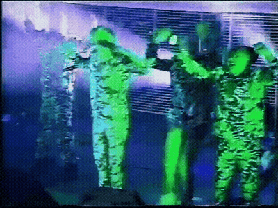 Group Of People Standing On Stage With Hands In Air GIF