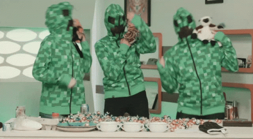 Group Of People Wearing Green Hoodies Standing Around Counter GIF