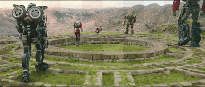 Group Of Robots Standing In A Circle In A Field GIF
