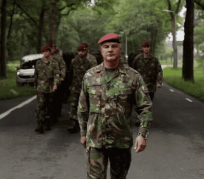 Group Of Soldiers Walking, One With Red Beret GIF