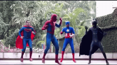 Group Of Superheroes Dancing On Sidewalk GIF