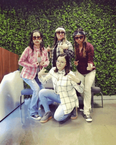 Group Of Women Posing In Front Of Hedge Wall GIF