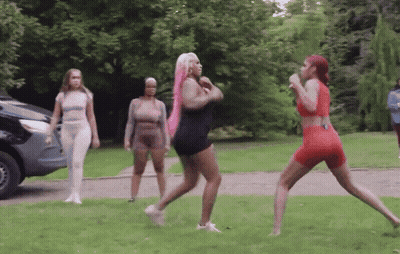 Group Of Women Standing In Grassy Area With Car GIF