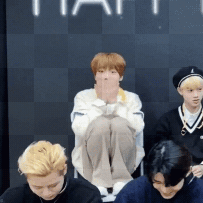 Group Of Young Men One Sitting Cross-Legged On Floor GIF
