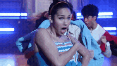 Group Of Young People Dancing In Dark Room With Surprised Woman GIF
