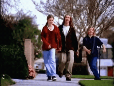 Group Of Young People Walking On Neighborhood Sidewalk GIF
