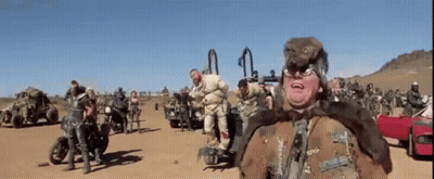 Group On Dirt Road, One Wearing Fur Coat GIF