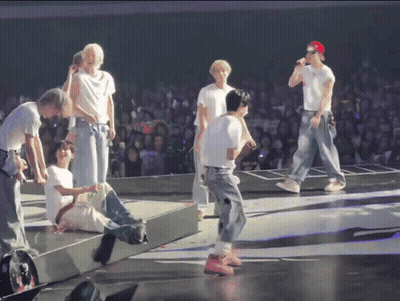 Group On Stage With Red Cap GIF