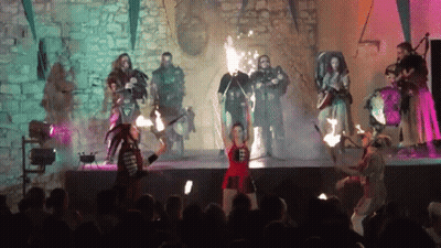 Group On Stage Woman Holding Torch GIF