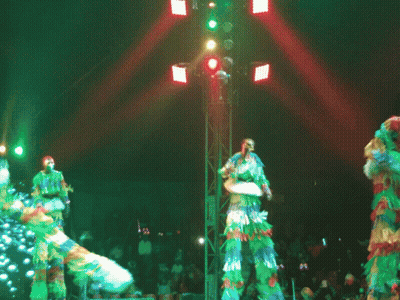 Group On Stilts Dancing In Front Of Crowd GIF