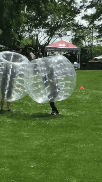 Group Playing Bubble Soccer In Grass GIF