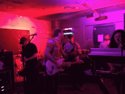 Group Playing Instruments In Front Of Exit Sign GIF