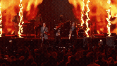 Group Playing Instruments On Stage With Fire GIF