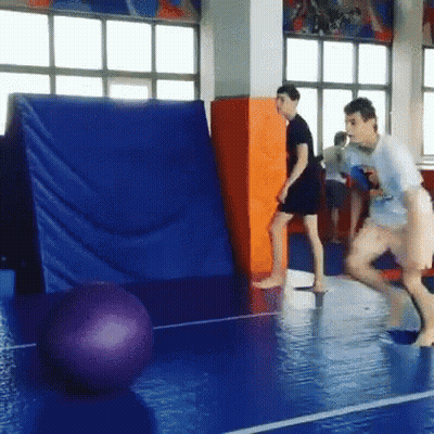 Group Playing Volleyball On Blue Mat In Gym GIF