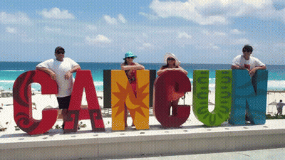 Group Posing In Front Of Cancun Sign GIF