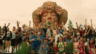 Group Posing In Front Of Face Sculpture GIF