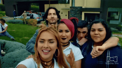 Group Posing With Nuestra Tele Logo GIF