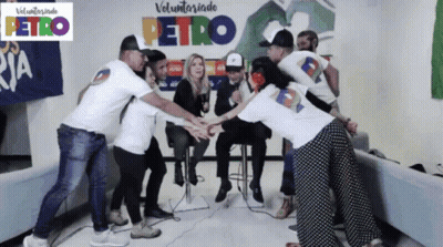 Group Putting Hands Together In Front Of Petro Sign GIF