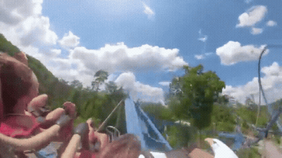 Group Riding Roller Coaster On Sunny Day GIF