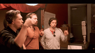 Group Sitting Around Table With Man Standing GIF