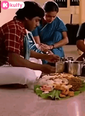 Group Sitting Around Table With Plate of Food