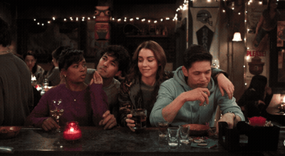Group Sitting At Bar With Please Sign GIF