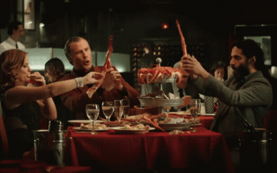 Group Sitting At Table Holding Crab Legs GIF