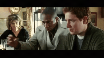 Group Sitting At Table One Holding Something GIF