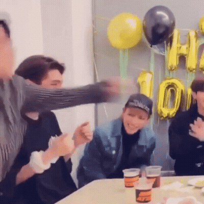 Group Sitting At Table With Balloons And Cups GIF