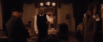 Group Sitting At Table With Man In Suit And Woman In White Dress GIF