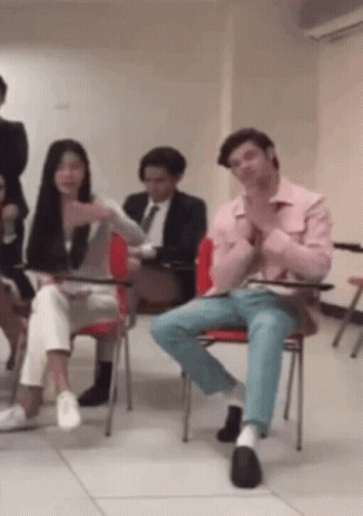 Group Sitting In Chairs With Man In Pink Shirt GIF