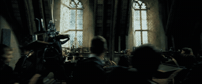 Group Sitting In Dark Room With Standing Man GIF