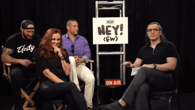Group Sitting In Front Of Hey (Ew) Sign GIF