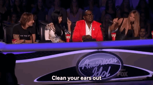 Group Sitting In Front Of Sign Clean Your Ears Out GIF