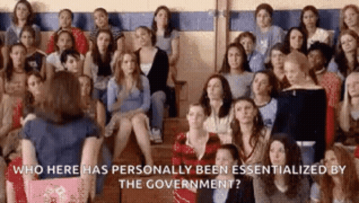 Group Sitting In Gym With Woman Standing In Front GIF