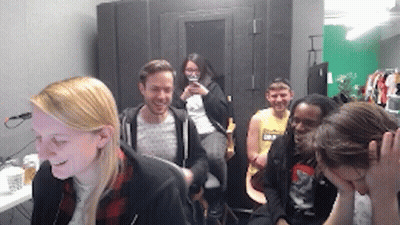 Group Sitting In Room One Holding Head GIF