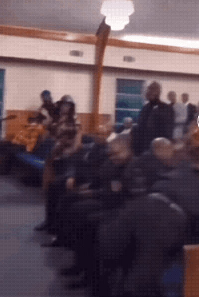 Group Sitting In Room With Cross GIF