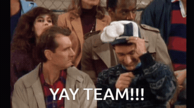 Group Sitting In Stadium With Yay Team Hat GIF