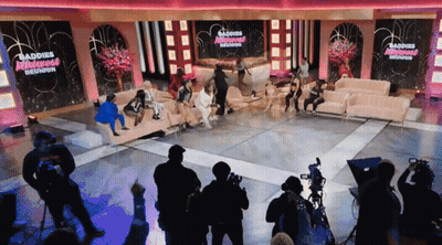 Group Sitting On Couch In Front Of Baddies Reunion Sign GIF