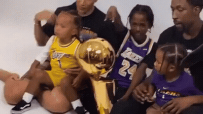 Group Sitting On Floor With Basketball Trophy GIF