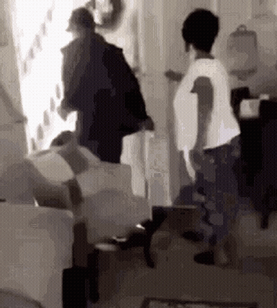 Group Standing Around Couch In Black And White GIF