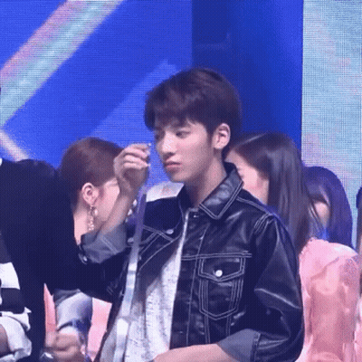 Group Standing Around Man In Leather Jacket Holding Necklace GIF
