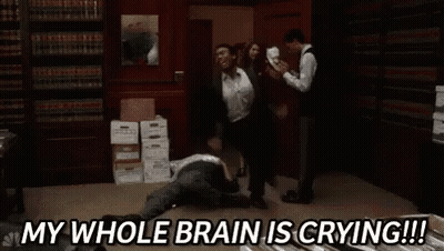 Group Standing Around Man Laying On Floor In Library GIF