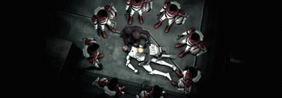 Group Standing Around Man Laying on Floor With Sign Saying The