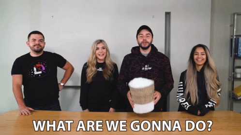 Group Standing Around Table What Are We Gonna Do GIF