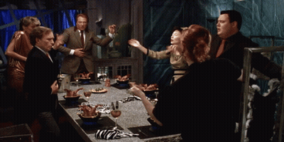 Group Standing Around Table With Food GIF