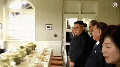 Group Standing Around Table With G GIF