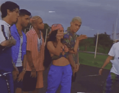 Group Standing Around Woman In Crop Top And Blue Shorts GIF