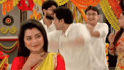 Group Standing Around Woman In Red And Yellow Sari GIF