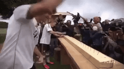 Group Standing Around Wooden Plank With Nails GIF